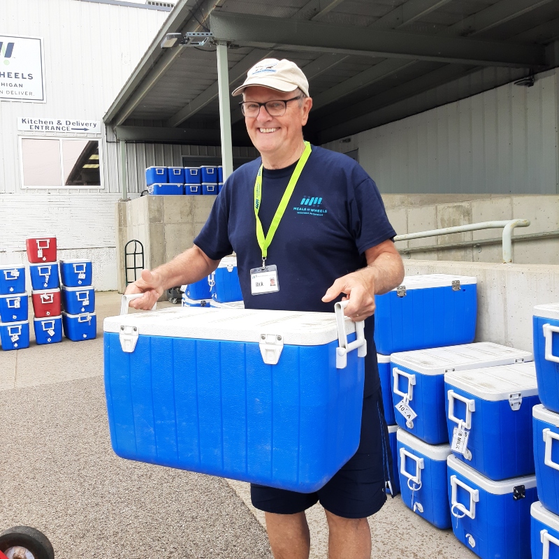 A MOWWM volunteer loads a cooler filled with Home Delivered Meals into his car.