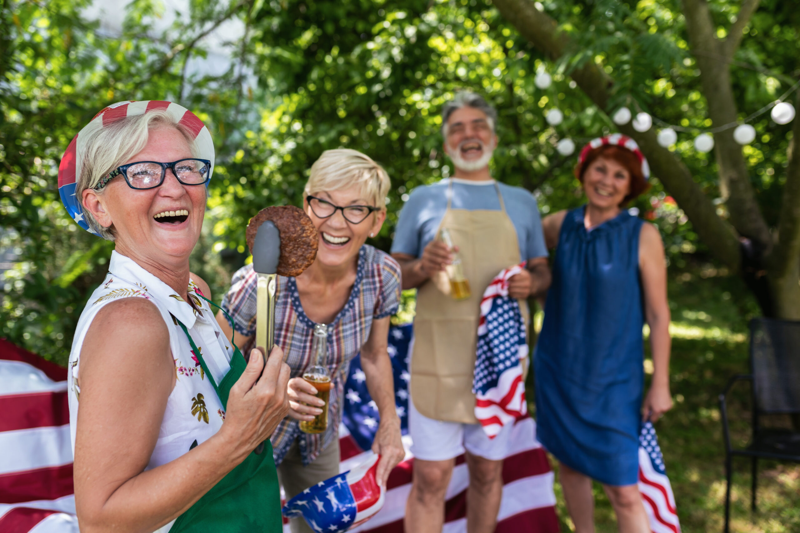 A group of elderly folks grill burgers and celebrate independence day.