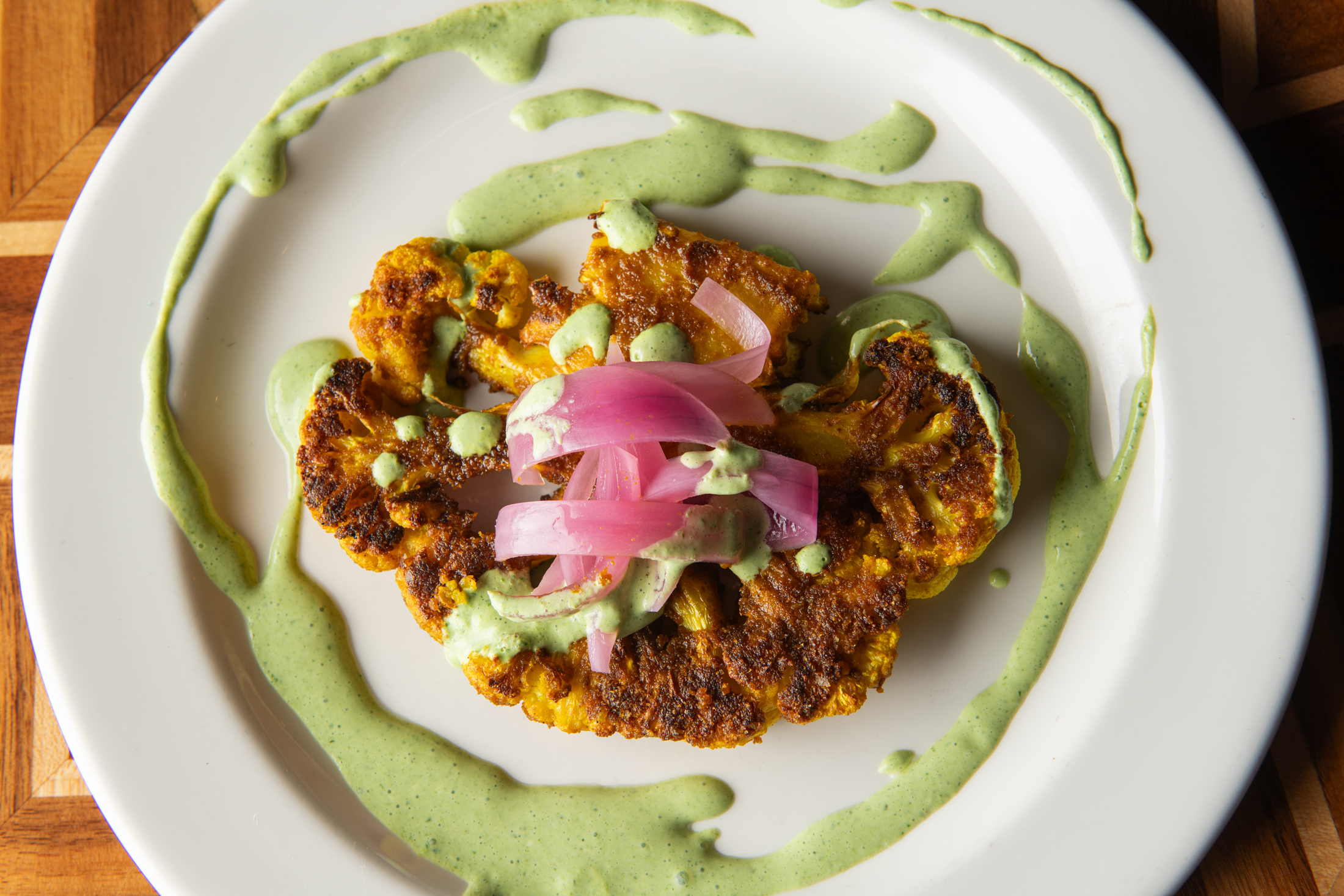 Alex Ewigleben's entry for the 2023 Chef's Specialty Recipe Competition: Curry Cauliflower Steak with Cilantro Yogurt and Pickled Red Onion