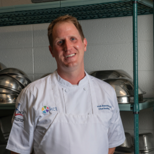 Chef Jacob Bandstra standing in a white chef coat and apron