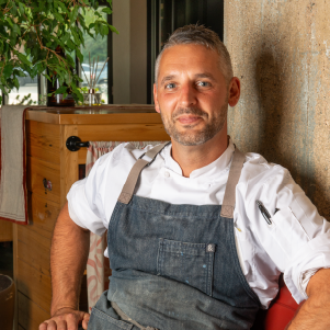 Clark Franklin wearing a chef apron while sitting in the dining room of Terra GR.