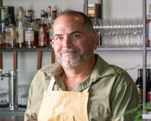 Chef Chris Weimer posing for a picture in front of a bar.