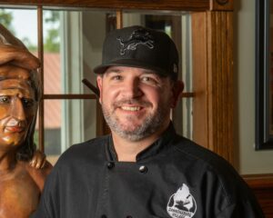 A headshot of Chef Michael Alexander standing in the restaurant, Cannonsburg Village.